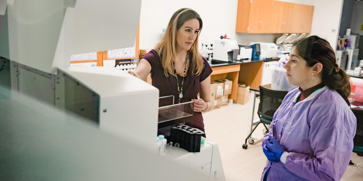 Instructor working with student in medical lab.