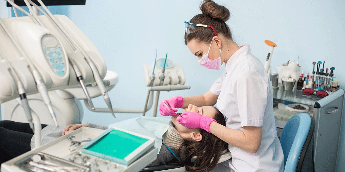 A dental hygienist cleans a patient's teeth